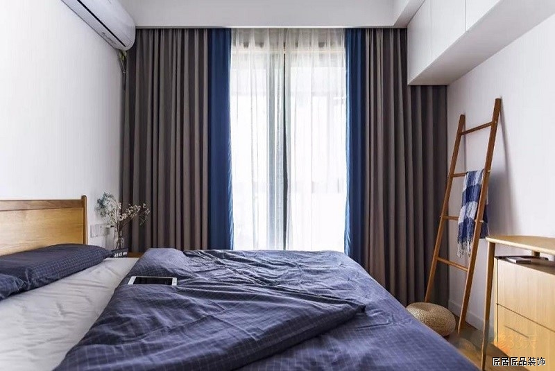 主卧延續留白(bái)搭配木色元素家具，藍(lán)灰色布藝軟裝調節空間色調比例