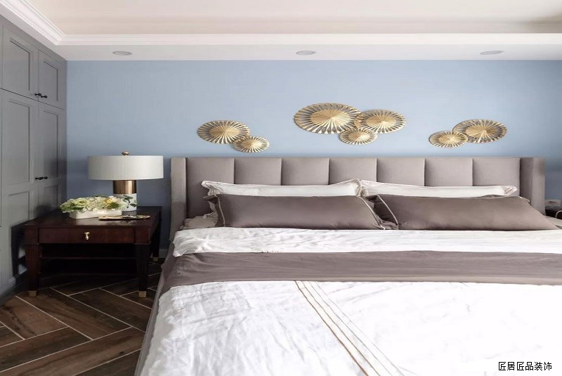 主卧，人字鋪木紋磚搭配藍(lán)色背景，點綴金色牆飾，淺咖色高背床搭配咖色與白(bái)色床品，打造靜谧舒适的就寝環境
