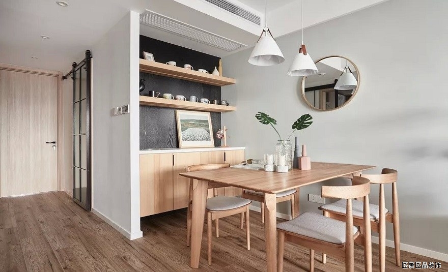餐廳原木色餐桌配套使用，空間聯系緊密，兩者之間可以相互補光。牆壁以鏡子代替裝飾畫，實用性更強。