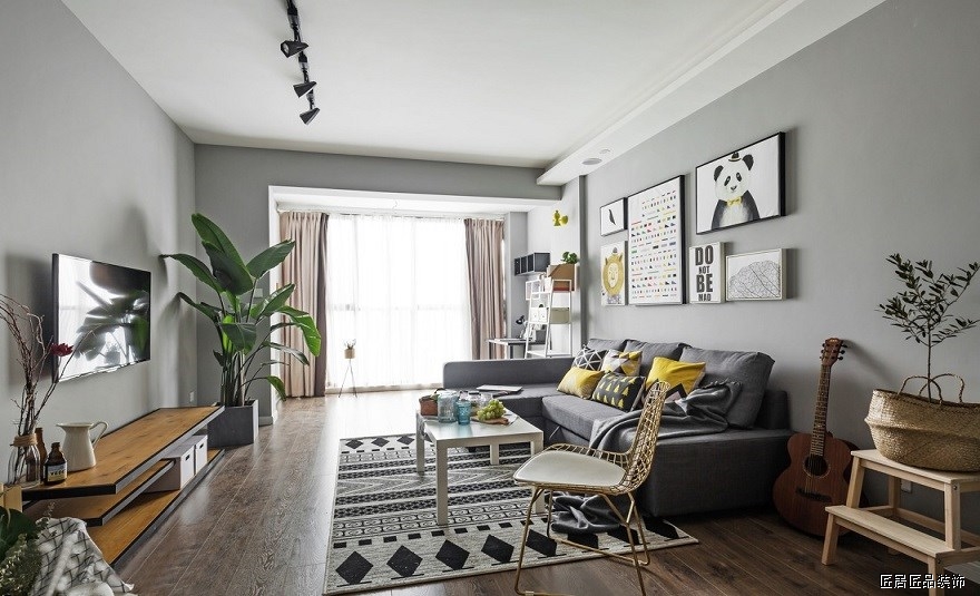 沙發上放(fàng)置了黃色抱枕，配色與後方挂畫相互呼應，爲整個空間提亮色彩。