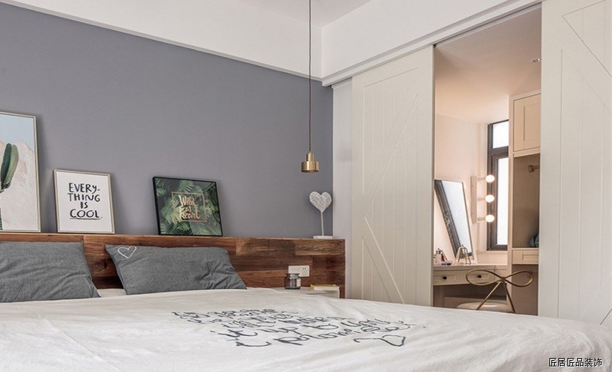 卧室采用木質床背闆延伸至木質地闆，借此拉長空間感。床頭簡單幾幅畫根據季節心情随意更換，美好靈動。